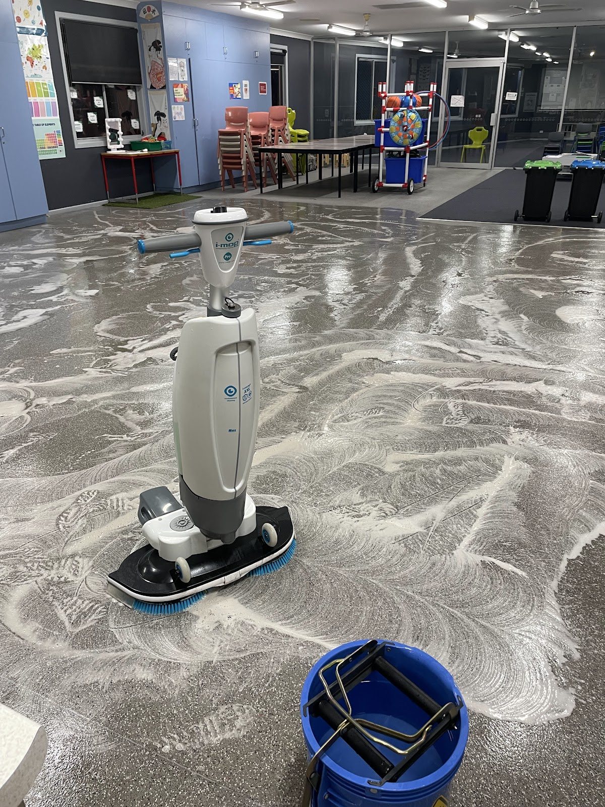 Scrubber-dryer working across a soapy classroom floor