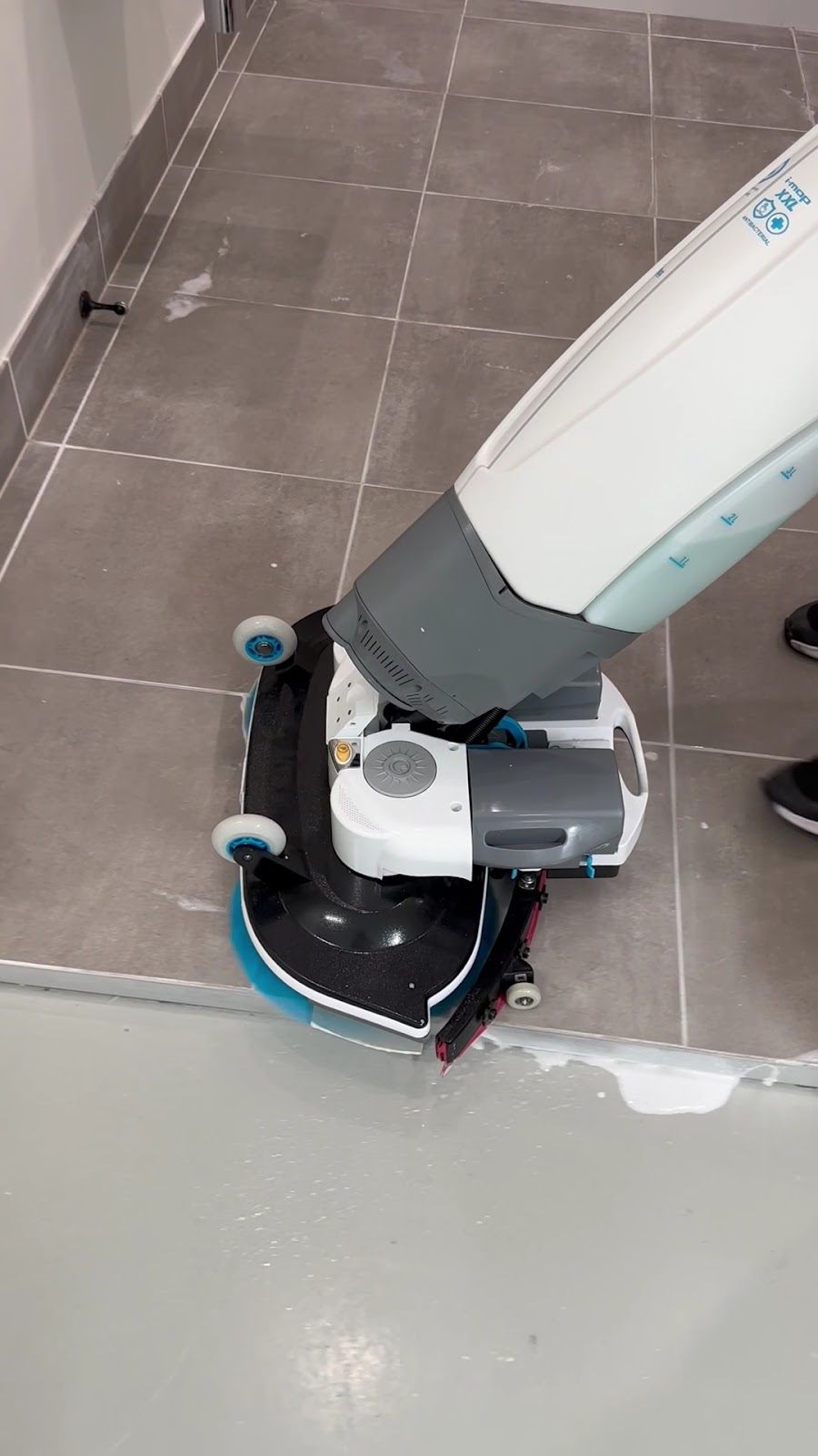 Close-up of a scrubber head on grey tiles